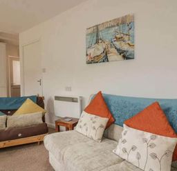 A living room with a sofa and cushions at Bungalow Sleeps 2 Parking in Newquay