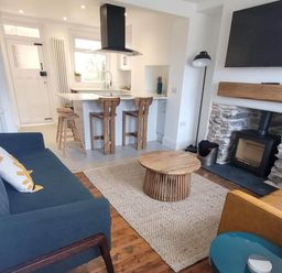 A living room with a sofa and coffee table at Looe Cottage Seaside views log fire sleeps 4 in Looe