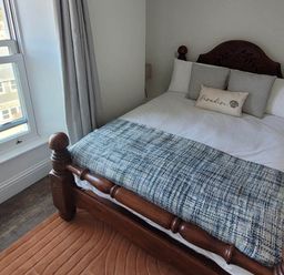 A bedroom with a bed and window at Looe Cottage Seaside views log fire sleeps 4 Looe