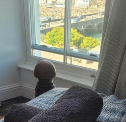 A view from a bedroom window with a towel on a bed at Looe Cottage Seaside views log fire sleeps 4 in Looe