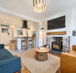 A living room with a sofa, armchair, coffee table, and television at Looe Cottage Seaside views log fire sleeps 4 Looe