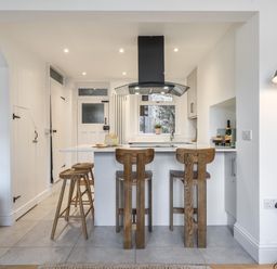 A kitchen with bar stools and countertop at Looe Cottage Seaside views log fire sleeps 4, Looe