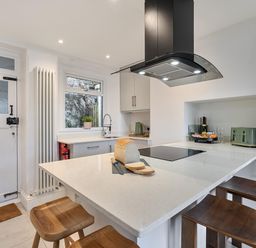 A kitchen with countertop and stools at Looe Cottage Seaside views log fire sleeps 4 in Looe