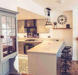 A kitchen with a counter and stools at 3Bed Cottage Plymouth Dog friendly Sleeps7