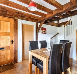 A dining room with a wooden table and chairs at Cabin Sleeps 6 with Parking and Patio in Tremail near Camelford