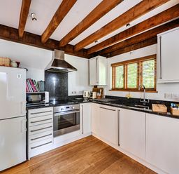 A kitchen with appliances and wooden beams at Cabin Sleeps 6 with Parking and Patio in Tremail near Camelford