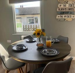 A dining room with a round table set for a meal at The Old Barn in Bridlington