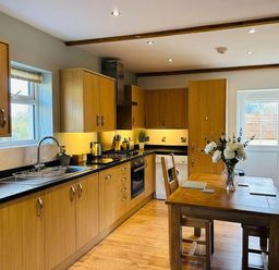 A kitchen with wooden units and a table at Nebo near Penygroes