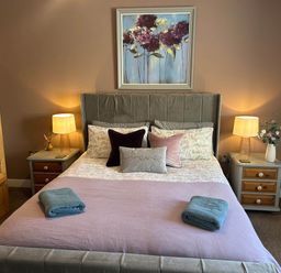 A bedroom with a bed and bedside tables at The Old Barn in Nebo near Penygroes