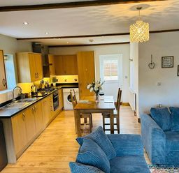 A kitchen with a dining table and sofa at The Old Barn in Nebo near Penygroes