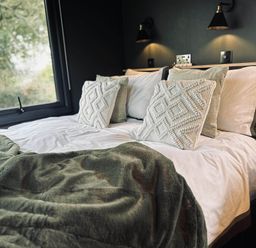 A bedroom with a bed and pillows at The Old Barn in Newton Abbot