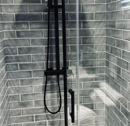 A shower with tiles and a glass door at The Old Barn in Newton Abbot
