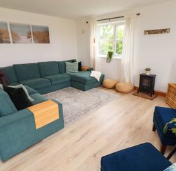 A living room with a sofa and a television at Alma House in Seahouses