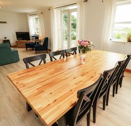 A dining room with a wooden table and chairs at Alma House in Seahouses