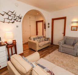 A living room with sofas and a television at Spinnaker