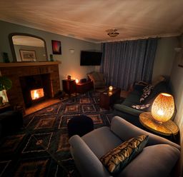 A living room with a fireplace and a television at Fables Cottage, Otley, Suffolk