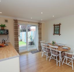 A kitchen with a dining area and sliding door at The Cosy Haven in Malton
