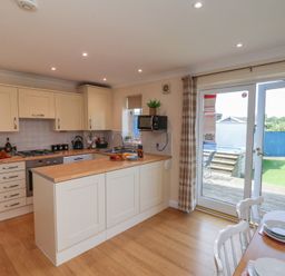 A kitchen with appliances and dining area at The Cosy Haven in Malton