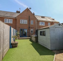 A garden with a house and a shed at The Cosy Haven in Malton