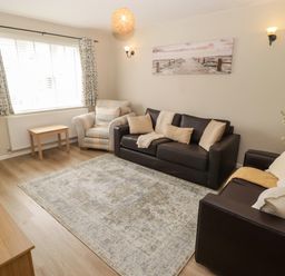 A living room with a sofa and armchair at 7 Cwrt Y Cadno in Llantwit Major