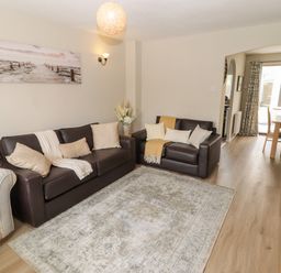 A living room with a sofa and a dining table at 7 Cwrt Y Cadno Llantwit Major