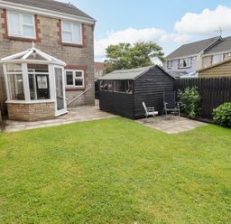A garden with a shed and conservatory at 7 Cwrt Y Cadno in Llantwit Major