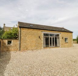 A building with doors and windows in a gravel area at Wayside in Moreton-in-Marsh