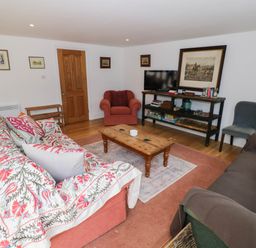A living room with sofas and a television at Wayside in Moreton-in-Marsh