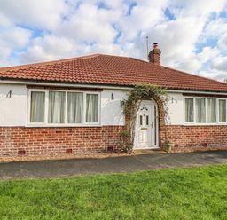 A house with a brick exterior and a front lawn at Westgate Willows in Nafferton