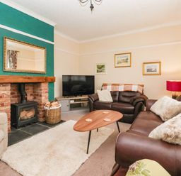 A living room with a fireplace and television at Westgate Willows in Nafferton