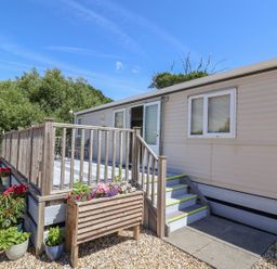 An exterior view of a mobile home with steps and railings at The Hideaway in Portesham