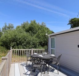 An outdoor deck with a table and chairs at The Hideaway in Portesham
