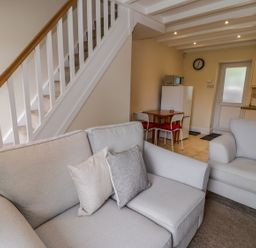 A living room with a sofa and dining table at Awelfryn in Betws-y-Coed
