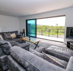 A living room with a sofa and television at Sycamore Cottage in Frizington