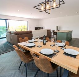 A dining area with a table set and a sofa visible at Silver Birch Cottage in Frizington