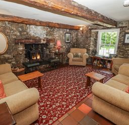A living room with a sofa, fireplace, and coffee table at Ty Mawr Country House, Carmarthen