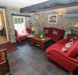 A living room with red sofas and a coffee table at Ty Mawr Country House in Carmarthen