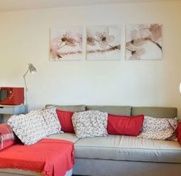 A living room with a sofa and paintings at Admirals Rest in Weymouth
