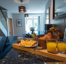 A kitchen with fruit and drinks on the counter at Gwynfryn House in Llanbedr