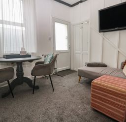 A living room with a table and chairs at 1 St. Day Road in Redruth