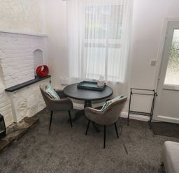 A living room with a table and chairs at 1 St. Day Road in Redruth