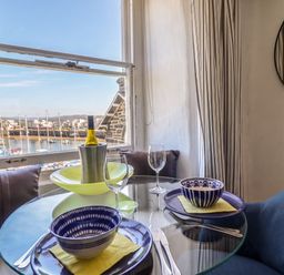 A dining table set with bowls and wine bottle at Cnicht View in Porthmadog