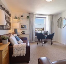 A living room with a sofa and dining area at Cnicht View in Porthmadog