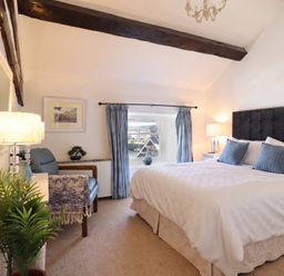 A bedroom with a bed, lamp, and chair at Cnicht View in Porthmadog