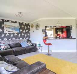 A living room with a sofa and bar counter at Excalabur 10 in Morfa Bychan
