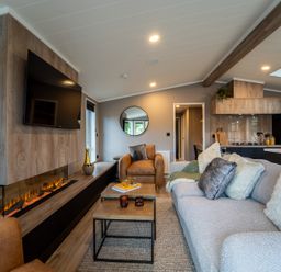 A living room with a sofa and television at Hideaway Lodge Llanfechell