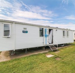 A mobile home with steps and windows at 42 Oak Green