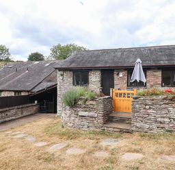 An outdoor view of a building with a stone wall and steps at Iris at Stancombe Manor Sherford near Chillington