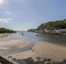 A river with boats and buildings alongside at Seafarer's Haven in Porthmadog