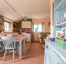 A kitchen with table and chairs and cabinets at The Granary in 